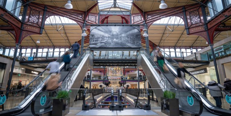 Entrance of Marketplace Shopping Centre with people on escalators